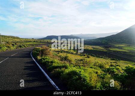 Route vide à pied de la vallée de montagne le long du champ avec verdure Dans les îles Canaries de Lanzarote Espagne Banque D'Images