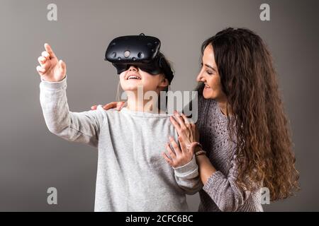 Une fille s'y porte avec un appareil VR et touche le doigt air Banque D'Images