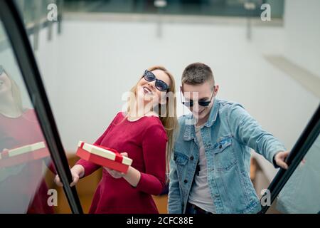 Trois copines sur escalator with shopping bags Banque D'Images