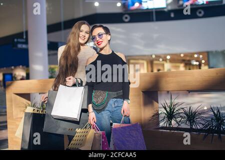 Portrait de deux filles caucasiennes gaies faisant du shopping dans le centre commercial Banque D'Images