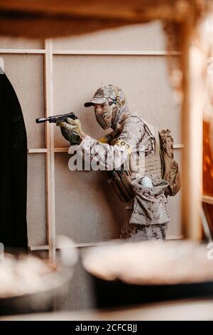 Soldat visant un fusil à air doux pendant un match tactique Banque D'Images