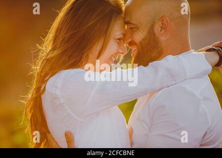 Couple romantique embrassé en se tenant dans un champ rural Banque D'Images