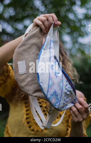 De dessous de jeune femme gaie avec des sacs faits maison ayant le plaisir de passer du temps à l'extérieur de la maison Banque D'Images