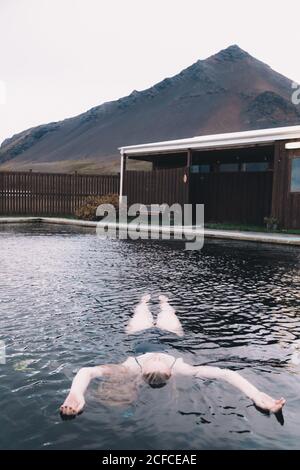 Femme se reposant dans l'eau de la piscine entre les terres sèches Banque D'Images