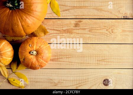 Cadre d'automne composé de citrouilles et de feuilles tombées sur une table en bois. Halloween, Thanksgiving, automne concept d'automne. Composition de la pose à plat, vue de dessus, copie sp Banque D'Images