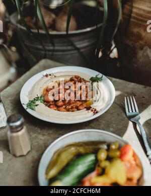 houmous de haricots dans l'assiette près de l'assiette de légumes Banque D'Images