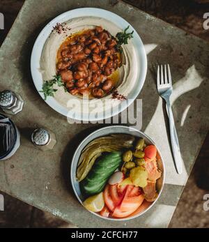 houmous de haricots dans l'assiette près de l'assiette de légumes Banque D'Images
