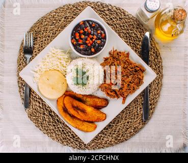 Cuisine vénézuélienne maison. Plat traditionnel vénézuélien. Pabellon Criollo. Riz blanc, haricots noirs, plantains frits et bœuf râpé Banque D'Images