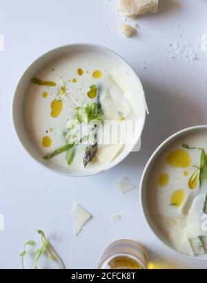 Deux bols de soupe à la crème d'asperges délicieuses avec fromage et herbes Banque D'Images