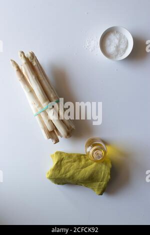 Serviette verte placée sur une table blanche près d'un bouquet de produits frais asperge d'huile et de sel Banque D'Images