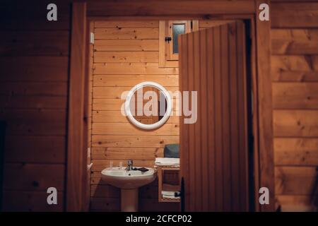 Salle de bains confortable dans une maison en bois avec porte ouverte et moderne équipement Banque D'Images