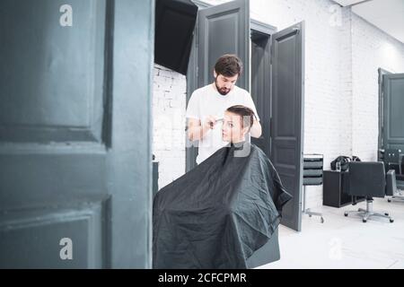 Coiffeur coupe les cheveux de la femme avec des ciseaux Banque D'Images