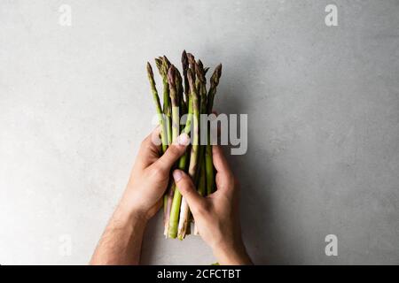 Cuire en tenant le bouquet d'asperges fraîches Banque D'Images