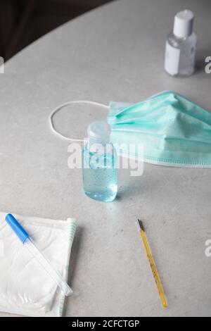 Du dessus gel antibactérien pour la prévention des coronavirus placé sur la table avec masque facial et thermomètre Banque D'Images