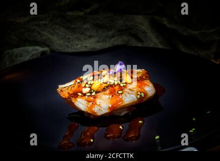 Délicieux sushis colorés appétissants avec sauce rouge et graines vertes sushi servi à table dans le restaurant Banque D'Images