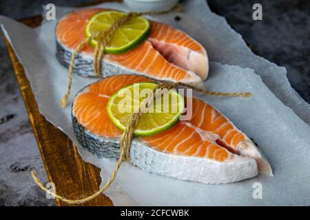 Deux steaks de poisson rouge crus et citron vert et prêt à cuire. Gros plan Banque D'Images