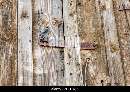 Porte en bois verrouillée par un verrou en fer rouillé Banque D'Images