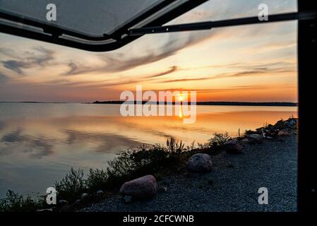 Vue depuis le camping-car au lever du soleil sur la mer. Banque D'Images