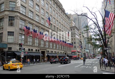 Bâtiment Saks Fifth Avenue bordé de drapeaux américains, New York City, États-Unis Banque D'Images