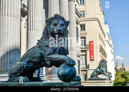 Une paire de grandes statues de lion ornent les marches d'un bâtiment du gouvernement dans le centre de Madrid, en Espagne. Banque D'Images