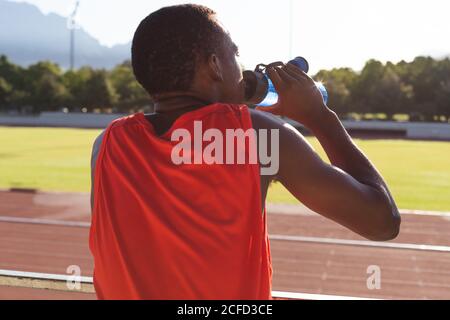 Athlète masculin avec de l'eau potable prothétique sur la piste de course Banque D'Images