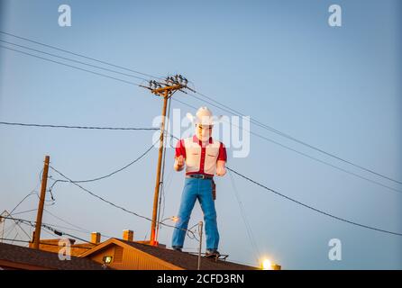 Lexington New Mexico USA - septembre 2015; Bib homme dans le grand chapeau texan fait de fibre de verre sur le toit du bâtiment. Banque D'Images