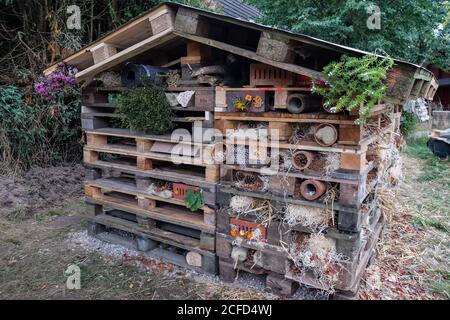 Grand hôtel d'insectes fait de palettes, de pierres perforées et de nombreux matériaux naturels Banque D'Images