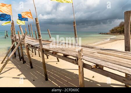 Jetée avec drapeaux colorés sur la plage d'Ao Wai, Koh Samet, Thaïlande Banque D'Images