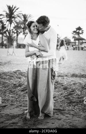Noir et blanc de l'homme et de la femme aimant adulte embrassant et embrassant sur la plage Banque D'Images