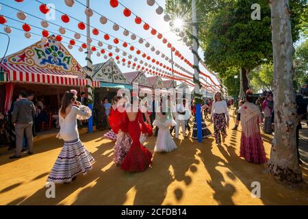 La femme espagnole avec des robes de flamenco en face de chapiteaux, Casetas, Feria de Séville, Séville, Andalousie, Espagne Banque D'Images