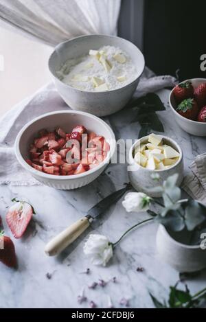 Divers ingrédients frais pour une savoureuse pâtisserie aux fraises placée sur du marbre table dans la cuisine Banque D'Images