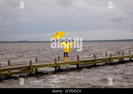 La jeune femme sur la jetée contrôle 0b il pleut encore. Steinhuder Meer, Allemagne Banque D'Images