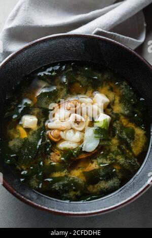 Du dessus du bol de soupe succulente à boulettes avec tofu et champignons placés sur une table au restaurant Banque D'Images