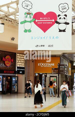 Intérieur de la station Ueno avec une grande bannière encourageant la distanciation sociale et le masque facial portant des personnes pendant l'épidémie de coronavirus. (9/2020) Banque D'Images