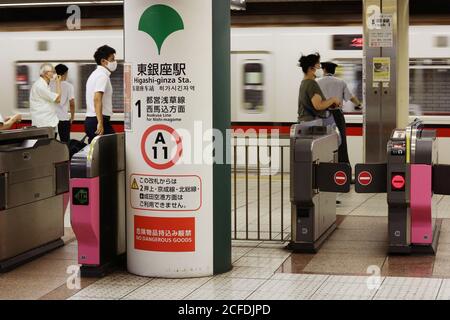 Train arrivant à la station de métro Higashi-Ginza de la ligne Toei Asakusa. Les gens portent des masques faciaux pendant l'épidémie de coronavirus. Flou de mouvement significatif. Banque D'Images