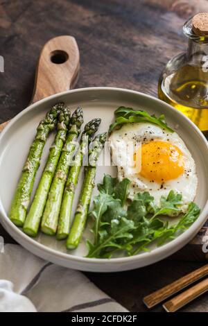 Petit déjeuner maison sain avec asperges, œuf frit et arugula. Quarantaine concept de saine alimentation. Régime de céto Banque D'Images