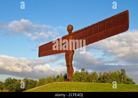 Le monument emblématique Ange de la statue du Nord à Gateshead, Tyne et Wear. Capturé dans la lumière dorée pour contracter la couleur de la rouille contre le bleu nuageux sk Banque D'Images