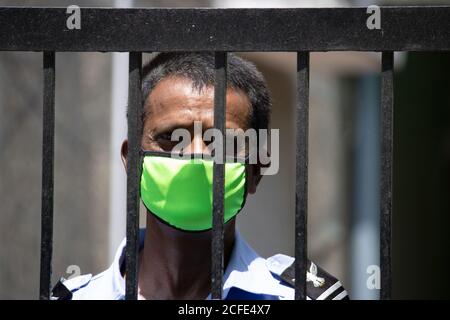 Un agent de sécurité portant un masque facial, face à l'appareil photo. Banque D'Images