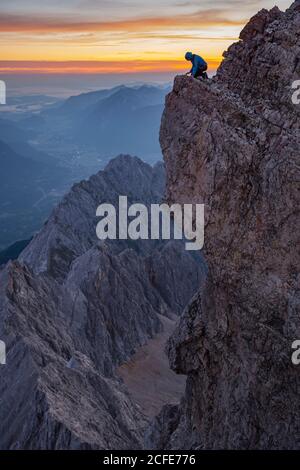 Un jeune homme au sommet du Zugspitze regarde dans le Höllental, en arrière-plan Garmisch-Partenkirchen et l'Estergebirge, Zugspitze, Grainau, Banque D'Images