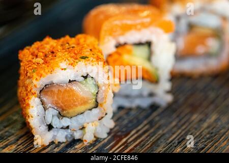 un trio de différents rouleaux de sushis californiens sur une assiette avec une sélection de remplissages Banque D'Images