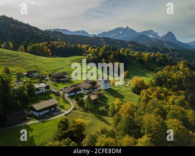 Wamberg avec l'église Saint Anna en automne, vue aérienne avec une vue sur la promenade vers les montagnes Wetterstein avec Alpspitze, Zugspitze et Banque D'Images