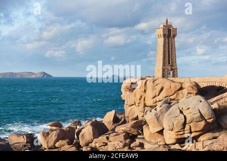 Hommes Ruz Côte de granit Rose phare en lumière d'automne. Banque D'Images