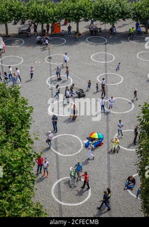 Duesseldorf, Rhénanie-du-Nord-Westphalie, Allemagne - promenade du Rhin en temps de la pandémie de corona, les gens sur Burgplatz avec des cercles peints pour social Banque D'Images