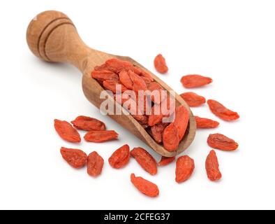 Baies de goji séchées dans une cuillère en bois isolée sur blanc Banque D'Images