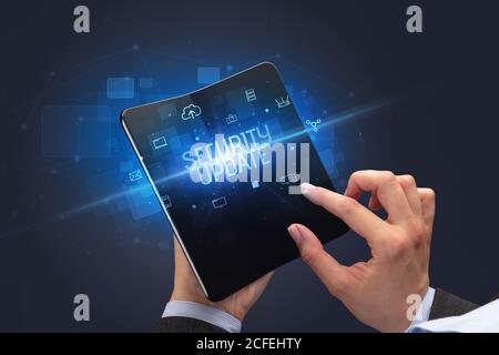 Businessman holding a smartphone pliable avec inscription MISE À JOUR DE SÉCURITÉ, cyber security concept
