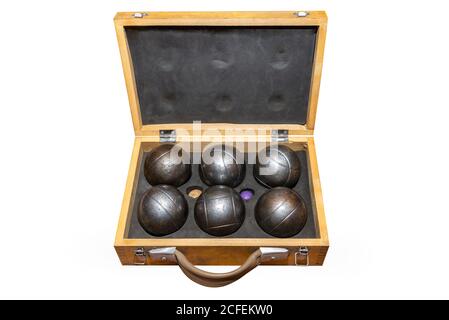 Six boules en métal placées dans une ancienne boîte en bois, utilisées dans le pétanka de jeu, isolées sur un fond blanc avec un chemin d'écrêtage. Banque D'Images