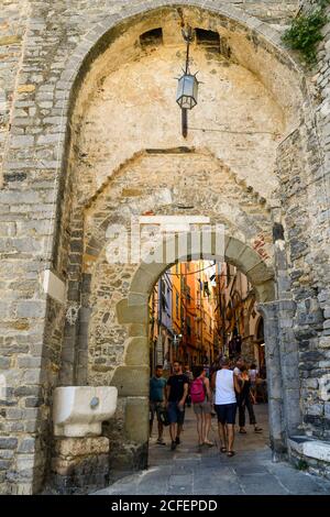 La porte médiévale du village de pêcheurs avec les touristes marchant dans la ruelle étroite en été, Porto Venere, la Spezia, Ligurie, Italie Banque D'Images