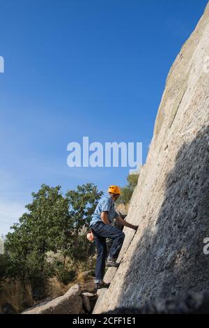 De dessous de l'alpiniste libre méconnaissable escalade dans la nature Banque D'Images