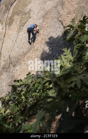 De dessous de l'alpiniste libre méconnaissable escalade dans la nature Banque D'Images