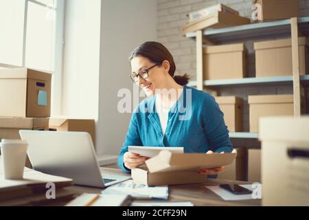 Femme travaille à l'entrepôt pour le vendeur en ligne. Concept de petite entreprise Web. Banque D'Images